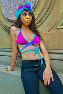 Polo Stripe Aphaea crochet wrap top with turquoise trim and crisscross waist ties, seated three-quarter front view