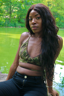 Model wearing the Aphaea crochet wrap top in Camo by a pond.